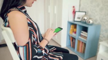 Yeşil ekran ile elinde bir akıllı telefon tutan güzel kız