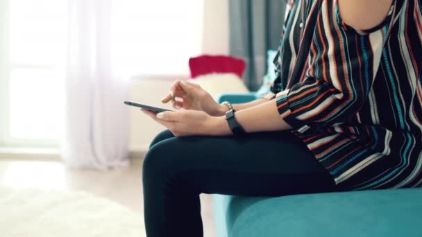 Hezká mladá žena používající smartphone na gauči — Stock video