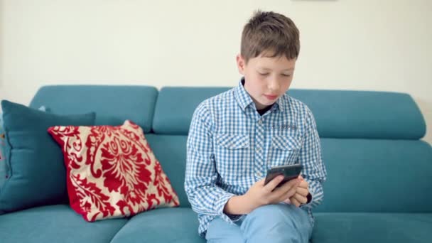 El niño sostiene un teléfono en la mano con una pantalla verde — Vídeo de stock