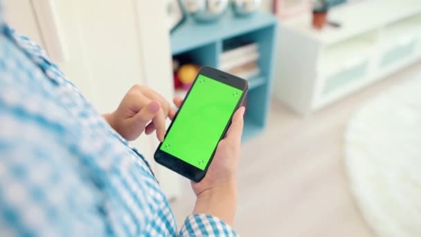 A criança está segurando um telefone na mão com uma tela verde — Vídeo de Stock