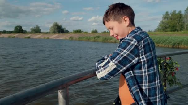 Heppy çocuk nehir yakınındaki iskelede duruyor — Stok video