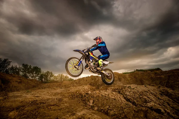 Professionele Motorrijder Rijden op de bergen en verder naar beneden de off-road track. De zonsondergang. — Stockfoto