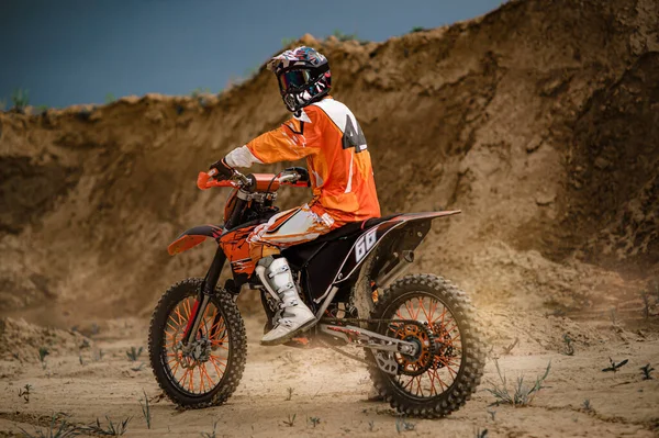 Professionele Motorrijder Rijden op de bergen en verder naar beneden de off-road track. De zonsondergang. — Stockfoto