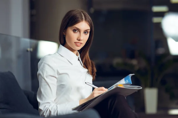 Portret młodej biznesmenki siedzącej w biurze w miejscu pracy. — Zdjęcie stockowe