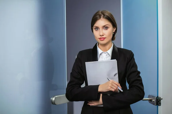 Experto en negocios seguro. Atractiva joven sonriente mujer en ropa casual inteligente y mirando a la cámara . Imagen de stock