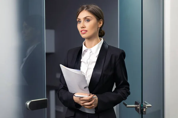 Elinde dosyaları tutan güzel, gülümseyen iş kadını.