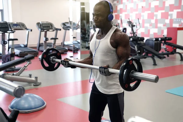 Tipo Negro Musculoso Con Una Camiseta Blanca Auriculares Sostiene Barra — Foto de Stock