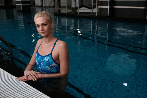 Havuzun kenarındaki kamera bakarak bir sarışın portresi. Yatay çerçeve