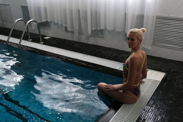 Een Aantrekkelijke Blonde Zit Aan Zijkant Van Het Zwembad Kijkt — Stockfoto