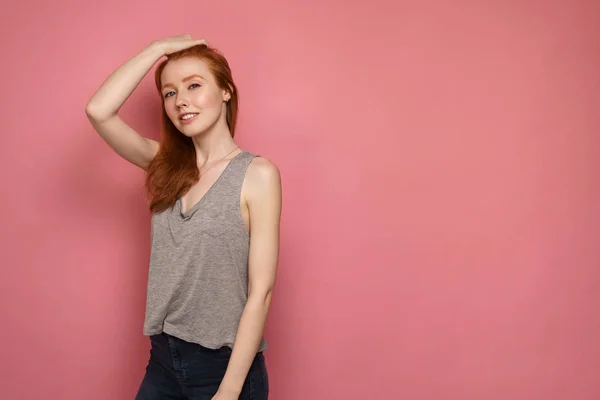 Young redhead girl smiles at the camera smoothing hair with one — 스톡 사진