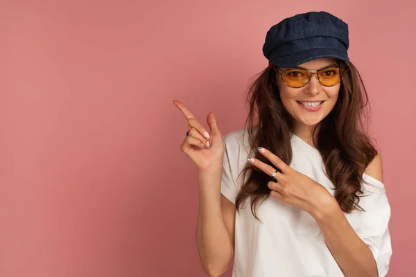 Junge dunkelhaarige Frau mit gelber Brille und dunkler Kappe — Stockfoto