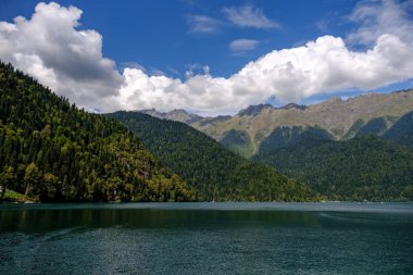 Güneşli bir günde dağlarla çevrili Ritsa Gölü