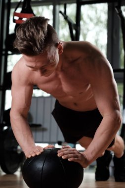 Çıplak gövdeli kaslı bir adam topun üzerinde, büyük bir atışta kırılır..