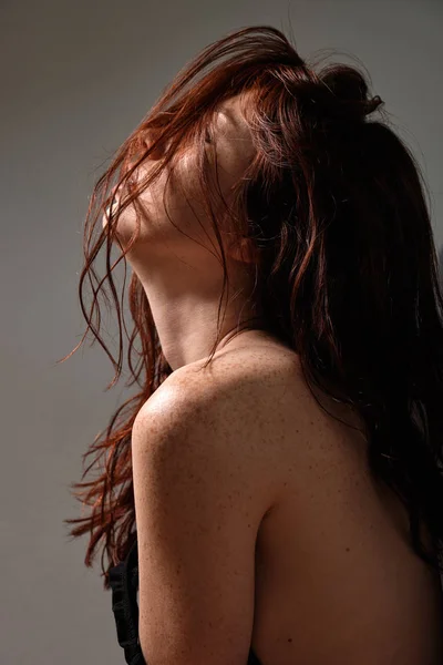Egy vörös hajú lány, a napon a profil portréja, haja az arcán. — Stock Fotó