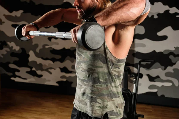 Hombre muscular eleva la barra hacia el pecho, marco grande — Foto de Stock