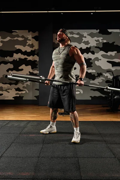 Uomo gonfio in uniforme sportiva e berretto da baseball in palestra con avvoltoi tra le mani, alzando la testa — Foto Stock