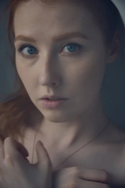 Fechar retrato de uma menina de cabelos vermelhos com olhos azuis, foto através de uma cortina de luz . — Fotografia de Stock