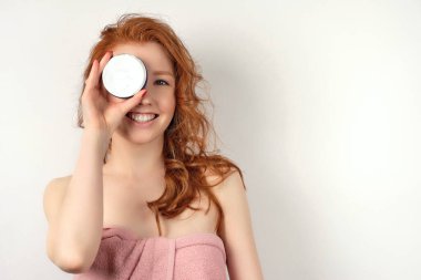 Beyaz arka planda kızıl saçlı kız, kanepenin bir tarafını kapatıyor.