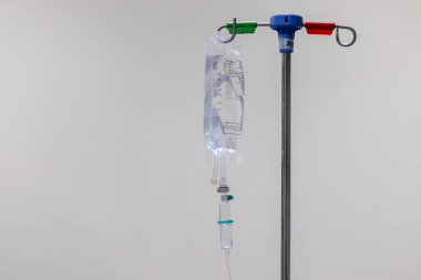 Beyaz arka planlı kazıklarda asılı bir serum ya da damar içi sıvı torbası.