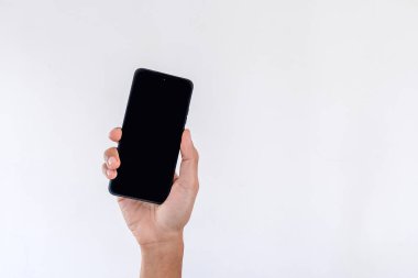 Beyaz arka planda boş ekranlı cep telefonu tutan bir adam.