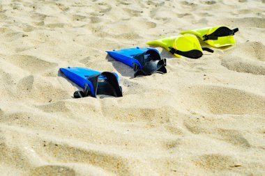 Dalış için sarı ve mavi kolların üst üste kum üzerinde yalan