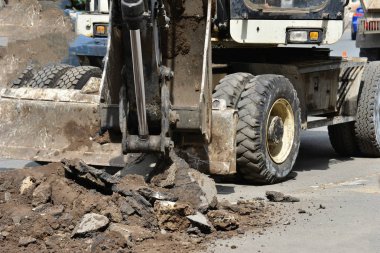 Yeni bir yol döşeme için eski asfalt bir ekskavatör kaldırır