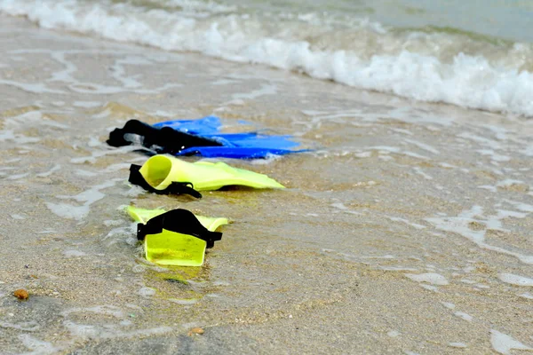 用于潜水的黄色和蓝色鱼翅躺在水中的海滩上 — 图库照片