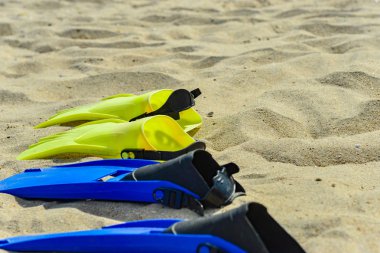 Dalış için sarı ve mavi kolların üst üste kum üzerinde yalan