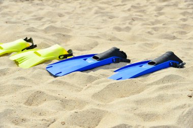 Dalış için sarı ve mavi kolların üst üste kum üzerinde yalan