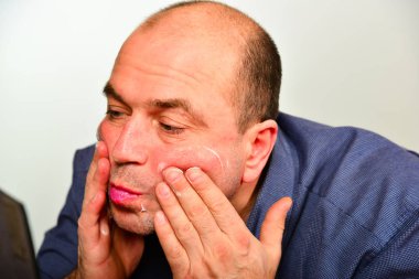 Bir yetişkin ve tıraşsız adam mavi gömlekli krem maske yüzünde, moda, stil ve kişisel bakım kavramı geçerlidir.