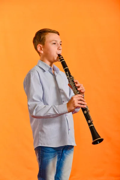 Fiú Végez Szólóban Egy Koncerten Klarinétozik Narancssárga Háttér — Stock Fotó