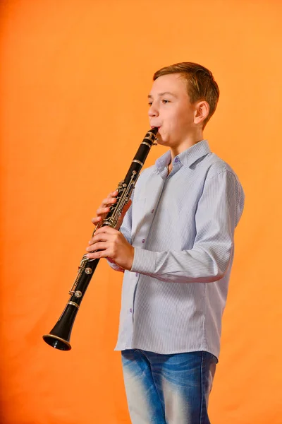 Menino Apresenta Sozinho Concerto Toca Clarinete Fundo Laranja — Fotografia de Stock