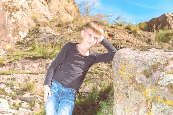 Chłopiec Pozuje Sesji Zdjęciowej Opierając Się Dużej Skale Skałach Podczas — Zdjęcie stockowe