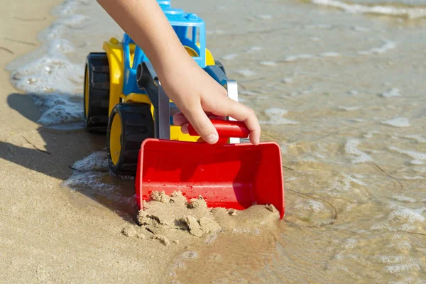 海の砂の上の子供のおもちゃのトラクター — ストック写真