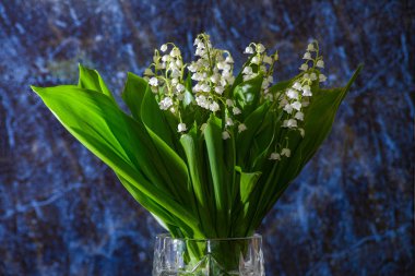 Cam vazo içinde vadinin bir buket zambak, mavi mermer arka planda vadinin lilyum