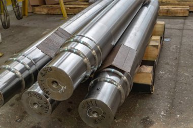 Büyük şaftlar, tornalama sonrası stokta.