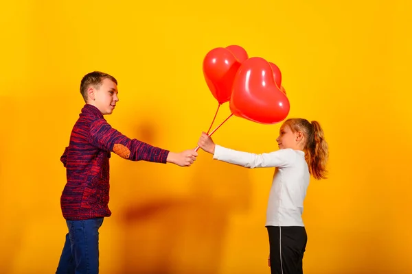 Τύπος Δίνει Στο Κορίτσι Ένα Μάτσο Κόκκινα Μπαλόνια Σχήμα Καρδιάς — Φωτογραφία Αρχείου