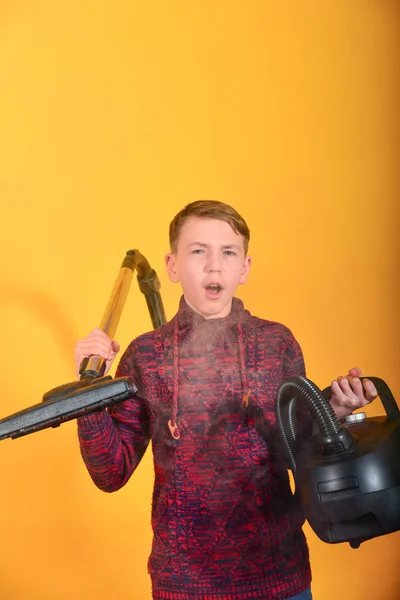 A guy with a vacuum cleaner in the smoke on a yellow background