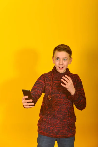 Chłopiec Smartfonem Żółtym Tle — Zdjęcie stockowe