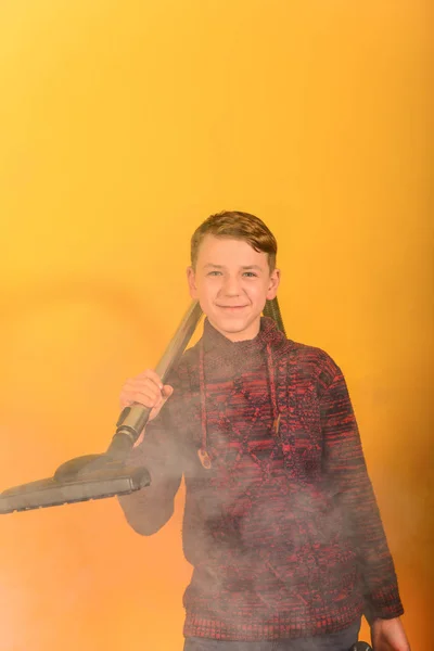 黄色の背景に煙の中で掃除機を持つ男 — ストック写真