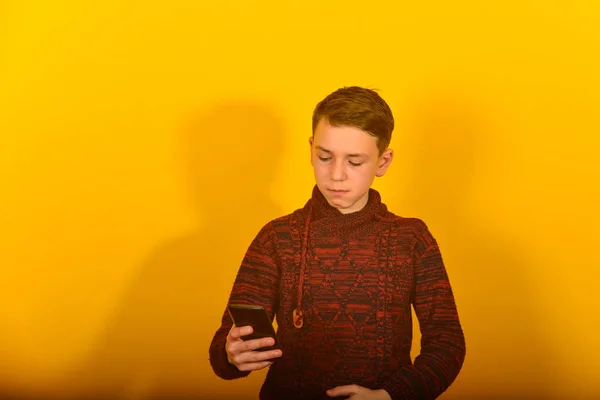 Chłopiec Smartfonem Żółtym Tle — Zdjęcie stockowe