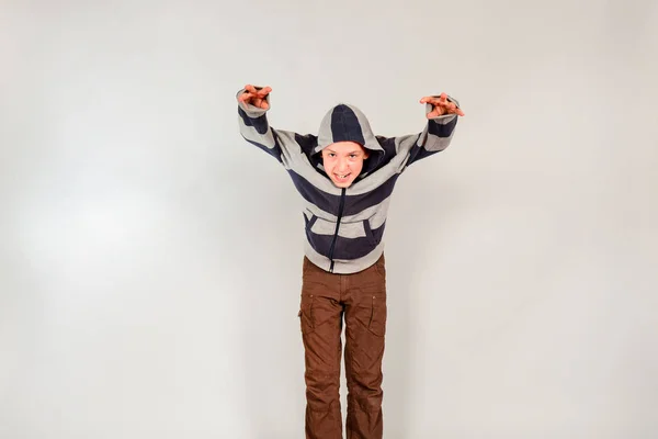 Хлопчик Капоті Тримає Руки Вгору Сірому Фоні Студії — стокове фото