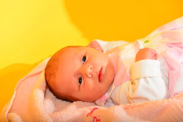 Foto Bebê Recém Nascido Uma Toalha Rosa Fundo Amarelo — Fotografia de Stock