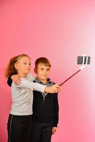 Chica Con Chico Hace Selfie Estudio Teléfono Inteligente Sobre Fondo —  Fotos de Stock