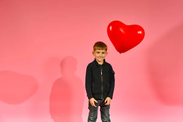 Chłopiec Rzuca Łapie Balon Kształcie Serca Różowym Tle Studiu — Zdjęcie stockowe