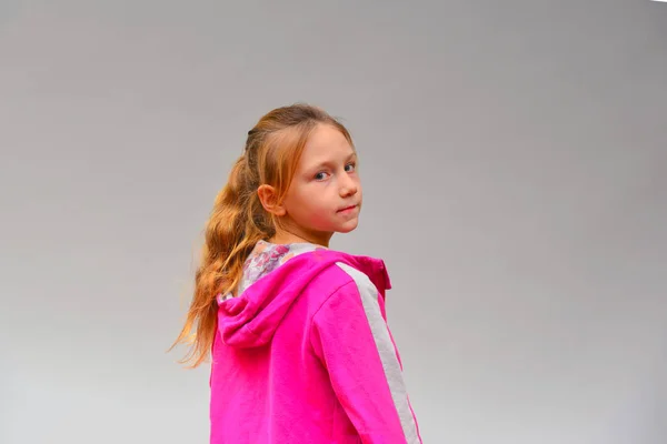 Portré Egy Lány Egy Rózsaszín Pulóvert Szürke Háttér Stúdióban — Stock Fotó