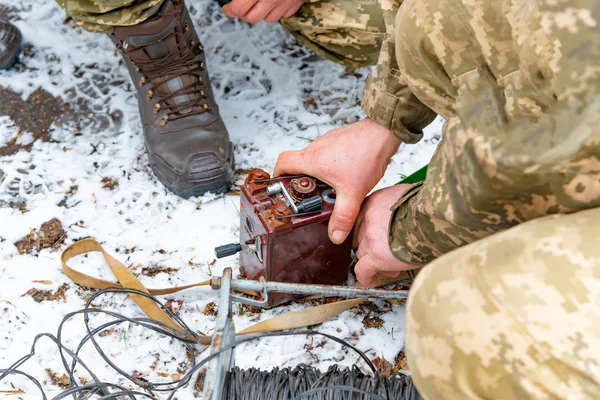 Military soldiers explode a bomb with a detonator.