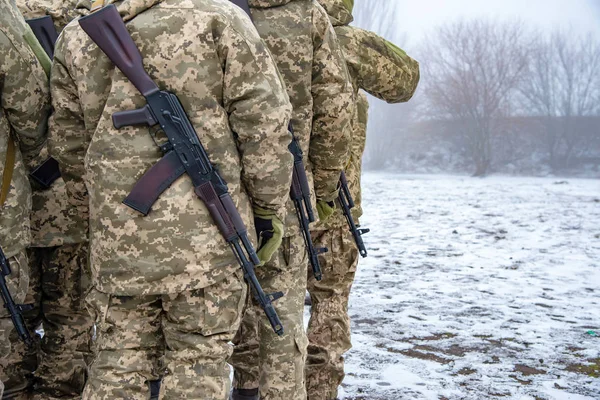 Story of military in camouflage with a firearm in winter
