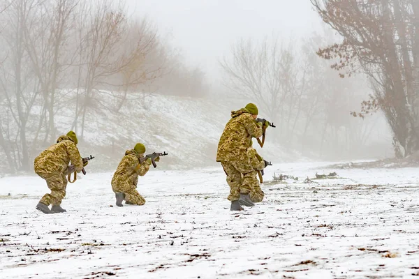 一个身穿武器伪装的战斗队在冬天继续进攻 — 图库照片