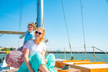 İki arkadaş direk yakınındaki bir yatta kucaklayan ve gelecekle ilgili rüya